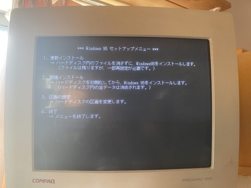 フロッピーディスクから起動したCOMPAQ Presarioの画面。青地に白文字で「*** Windows 95 セットアップメニュー ***」と表示され、更新インストール・新規インストール・区画の設定・終了の4項目が並んでいる