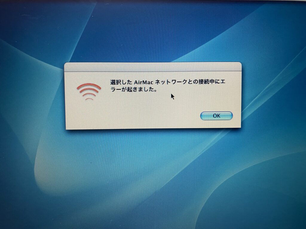 Mac OS X Panther の画面に「選択した AirMac ネットワークとの接続中にエラーが起きました。」というダイアログが表示され、赤い扇型の AirMac アイコンが並んでいる